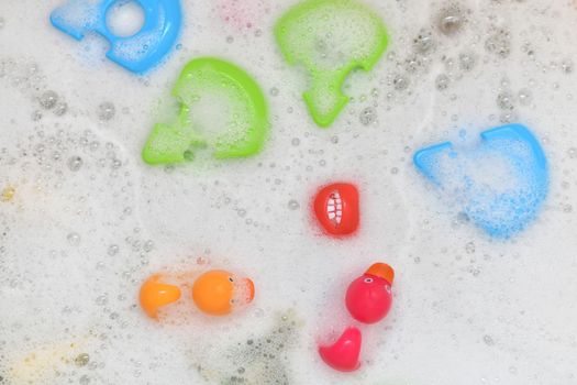 Rubber multicolored toys in a bubble bath for a baby