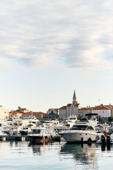 A pier with white yachts against the background of ancient houses and a beautiful cloudy sky. High quality photo