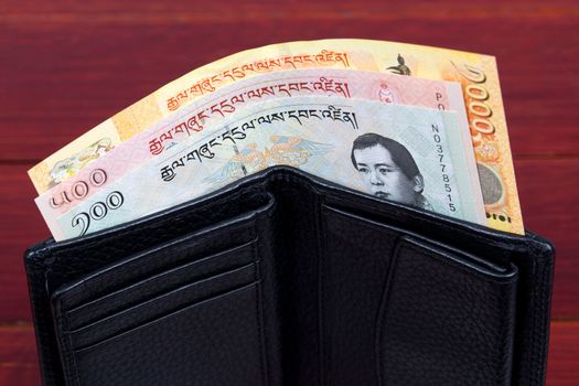 Bhutanese money -  ngultrum in the black wallet