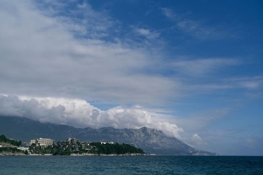 View from the sea to the beach, houses, trees and mountains. Budva, Montenegro. High quality photo
