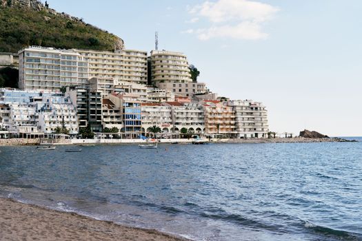 Beach and sea on the background of new beautiful buildings in the town of Rafailovici, Montenegro. High quality photo