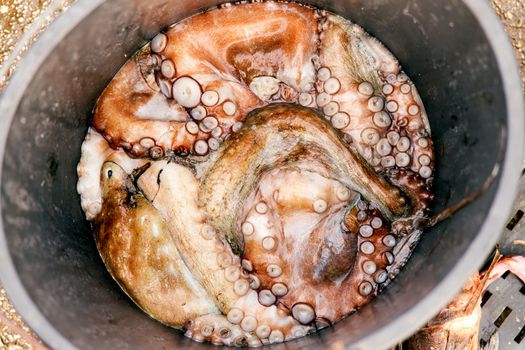 Octopuses with tentacles upwards lie in a bucket. Close-up. High quality photo