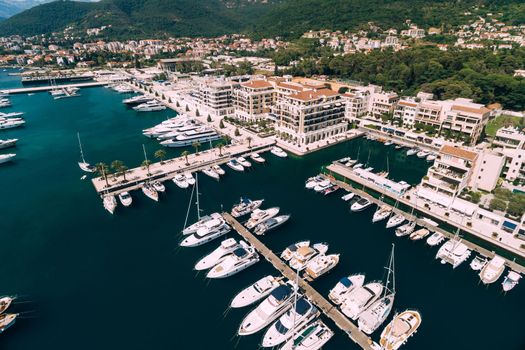 Aerial view of moored yachts near the modern buildings of the Porto resort. Montenegro. High quality photo