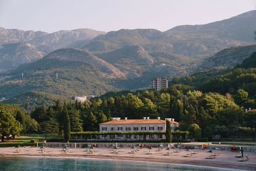 View from the bay to the sun loungers on the beach at Villa Milocer. Montenegro. High quality photo