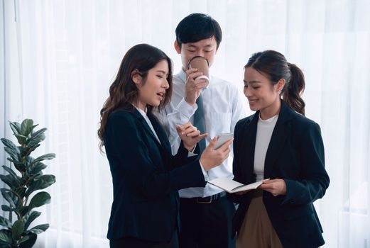 Mentor, manager with coffee advice younger colleagues in workplace. Businesspeople discussing or planning financial project strategy, talking together for harmony and strong teamwork in office concept