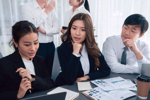 Harmony in office concept as business people analyzing dashboard paper together in workplace. Young colleagues give ideas at manager desk for discussion or strategy planning about project.