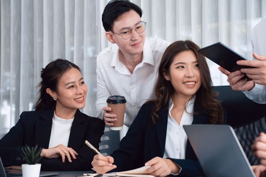 Harmony in office concept as business people analyzing dashboard paper together in workplace. Young colleagues give ideas at manager desk for discussion or strategy planning about project.