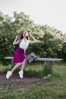 A fashionable girl with dark hair, a spring portrait in lilac tones in summer. Bright professional makeup