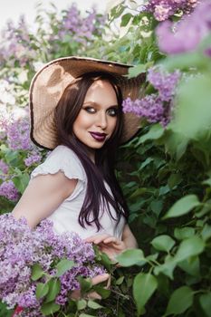 A fashionable girl with dark hair, a spring portrait in lilac tones in summer. Bright professional makeup