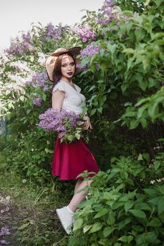A fashionable girl with dark hair, a spring portrait in lilac tones in summer. Bright professional makeup