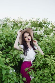 A fashionable girl with dark hair, a spring portrait in lilac tones in summer. Bright professional makeup