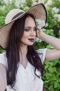 A fashionable girl with dark hair, a spring portrait in lilac tones in summer. Bright professional makeup