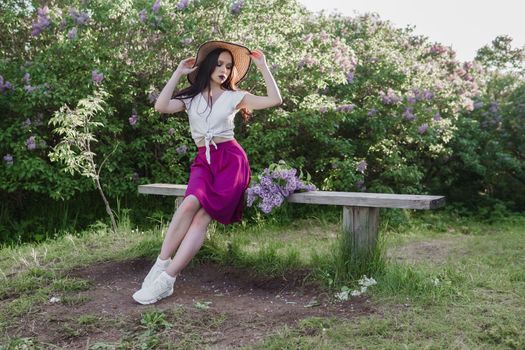 A fashionable girl with dark hair, a spring portrait in lilac tones in summer. Bright professional makeup