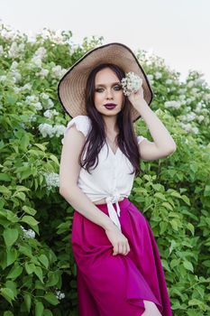 A fashionable girl with dark hair, a spring portrait in lilac tones in summer. Bright professional makeup