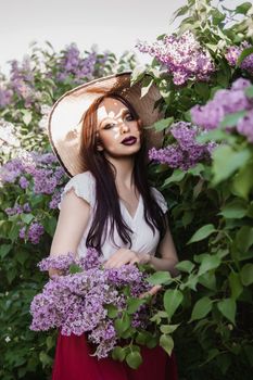 A fashionable girl with dark hair, a spring portrait in lilac tones in summer. Bright professional makeup