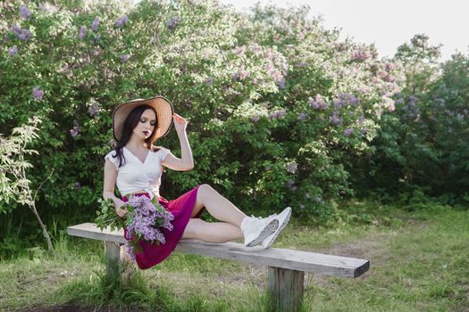 A fashionable girl with dark hair, a spring portrait in lilac tones in summer. Bright professional makeup