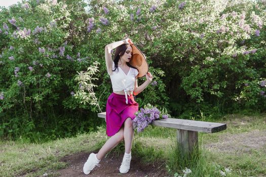 A fashionable girl with dark hair, a spring portrait in lilac tones in summer. Bright professional makeup