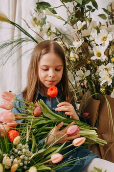 Two girls in a beautiful Easter photo zone with flowers, eggs, chickens and Easter bunnies. Happy Easter holiday