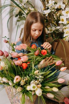 Two girls in a beautiful Easter photo zone with flowers, eggs, chickens and Easter bunnies. Happy Easter holiday