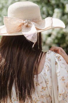 An attractive long-haired woman walks in the spring in the park of blooming apple trees. Spring portrait of a woman