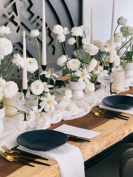 Served table with bouquets of flowers and candles in candlesticks. High quality photo