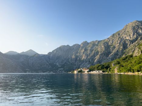 Old houses with red roofs at the foot of the mountainous coast. High quality photo