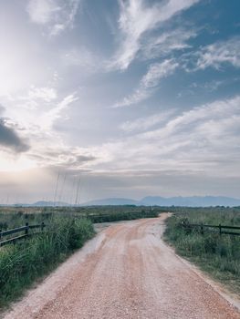 Wide country road among tall grass and wooden fences. High quality photo