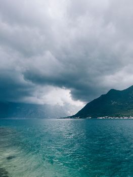 Dark stormy sky over the sea and mountains. High quality photo