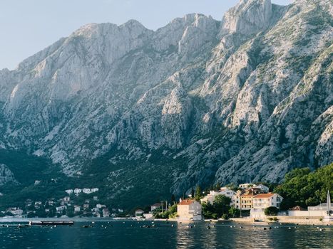 Buoys float off the coast of an old town with stone houses and red roofs. High quality photo