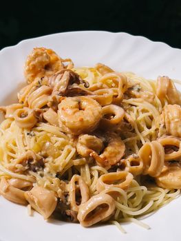 Shrimps in sauce lie on pasta in a plate. High quality photo