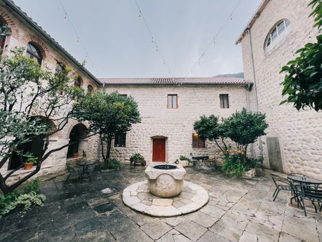 Round stone drinking fountain in the courtyard between ancient houses. High quality photo