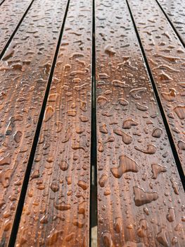 Raindrops on a brown wooden surface. Close-up. High quality photo