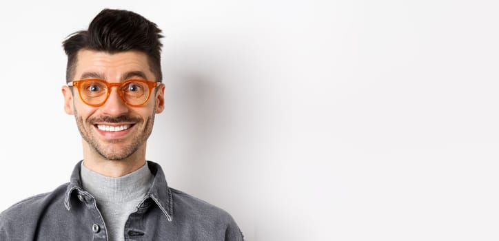 Close up portrait of happy man face, wearing stylish glasses and smiling, standing on white background.