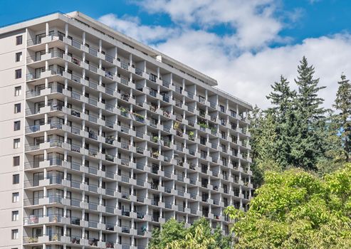 Back side of apartment residential building on blue sky background.