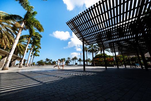 A couple in love runs through a square in San Sebastian de la Gomera, Canary Islands, Spain.