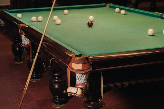 A pool table with balls that have already been played in the pool club.Playing billiards.