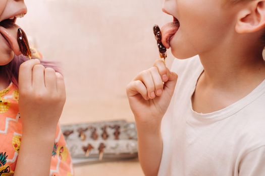 Children lick sugar lollipops.A taste of our childhood.Rooster lollipops.Sugar caramel.