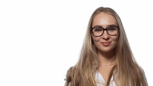 Beautiful girl in eye glasses with long straight blond hair looking at the camera wearing white medical uniform isolated on white background.