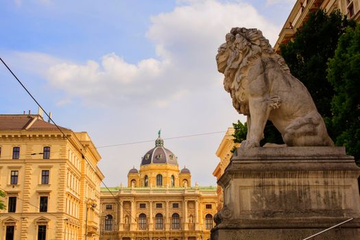Lion statue in front of the Palace of Justice. In the background the Natural History Museum. Vienna