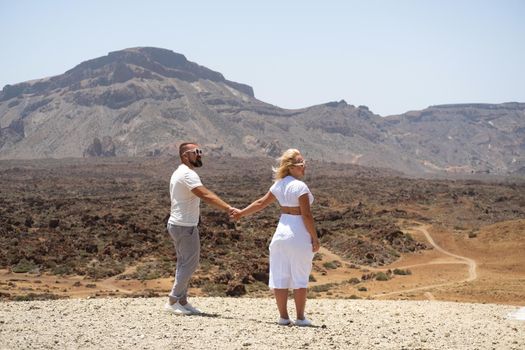 A couple in love hold hands in the crater of the Teide volcano.Tenerife, Canary Islands.