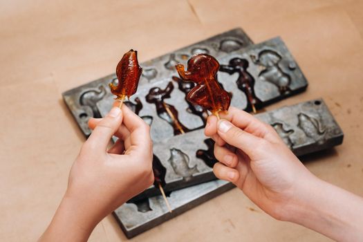 Making sugar lollipops at home.A taste of our childhood.Cockerel lollipops on a stick.Sugar caramel.