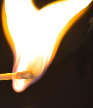 A selective focus of a match on fire on black background