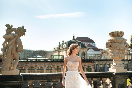 A bride in a white dress on a wedding walk at the famous Baroque Zwinger Palace in Dresden, Saxony, Germany.