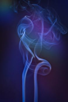 A vertical shot of smoke in colorfull backlight with a blue note