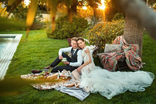 Newlyweds ' dinner on the lawn at sunset.A couple sits and drinks tea at sunset in France.