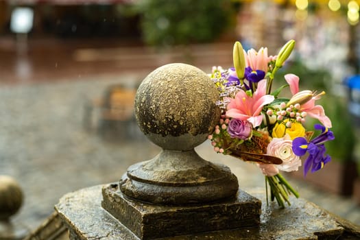 a wedding bouquet with lilies stands on the street in rainy weather.Wedding Decor.