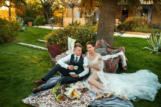 Newlyweds ' dinner on the lawn at sunset.A couple sits and drinks tea at sunset in France.