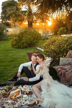 Newlyweds ' dinner on the lawn at sunset.A couple sits and drinks tea at sunset in France.