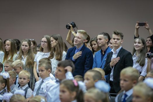 High school students on the line at school on September 1 listen to the national anthem with their hand to their hearts. Moscow, Russia, September 2, 2019