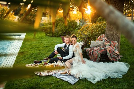 Newlyweds ' dinner on the lawn at sunset.A couple sits and drinks tea at sunset in France.